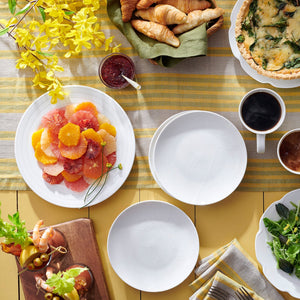 A table with raised Summer White Canapé Plates by Caskata Artisanal Home, of appetizer food and drinks, made from embossed porcelain.