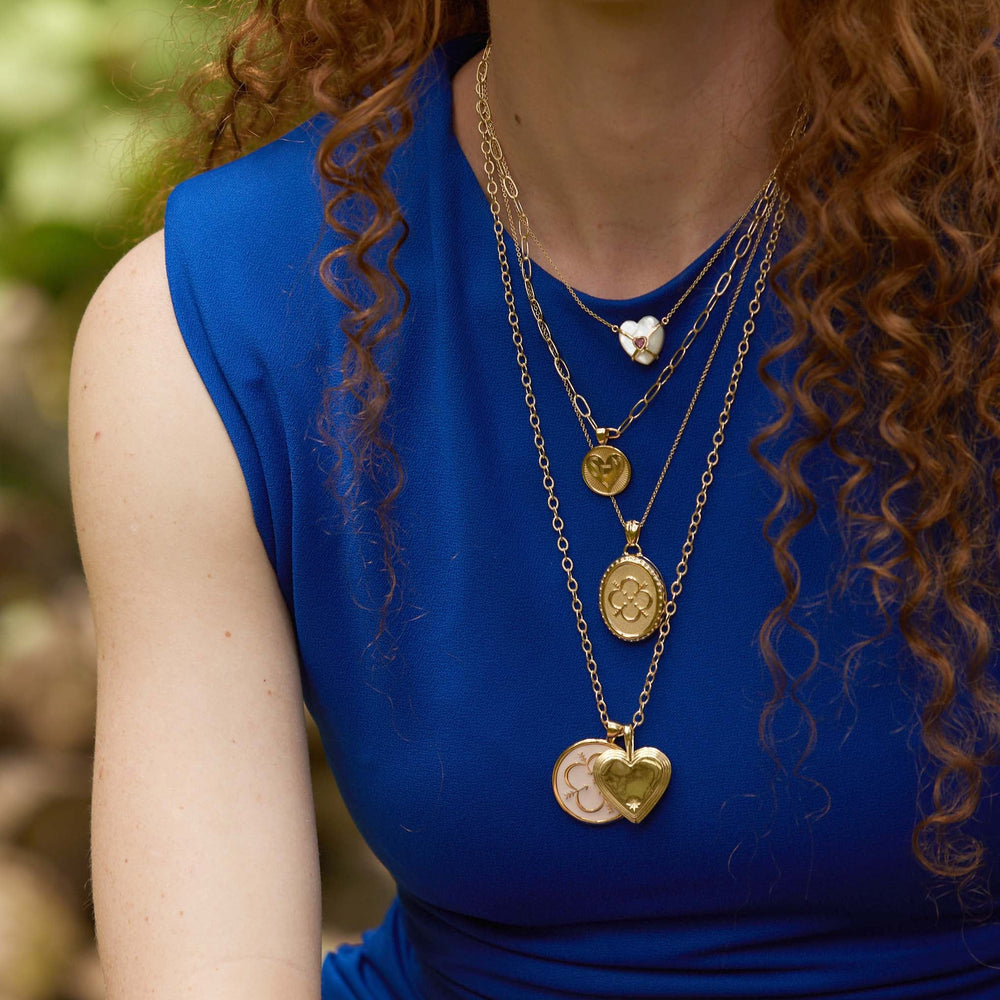 Close up of Layers Of Love Heart Necklace showcasing stacked heart and coin pendants on an adjustable gold satellite chain