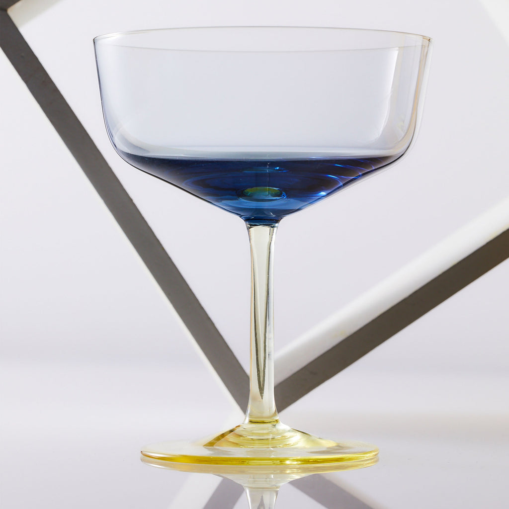 A Celia ocean blue and citrine yellow mouth-blown crystal coupe cocktail glass.
