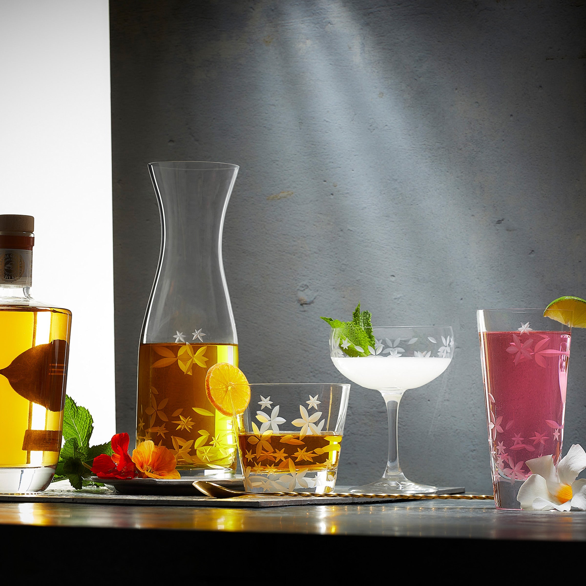 Chatham Bloom Collection etched floral pattern in lead-free crystal by Caskata. Pictured: carafe, tumbler, coupe and highball glasses.