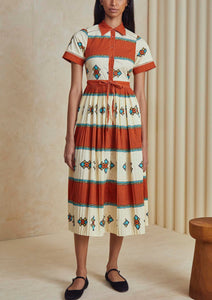 The Colby dress has short sleeves, a collared neckline, front button placket, and a pleated skirt.