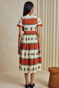 The Colby dress has short sleeves, a collared neckline, front button placket, and a pleated skirt.