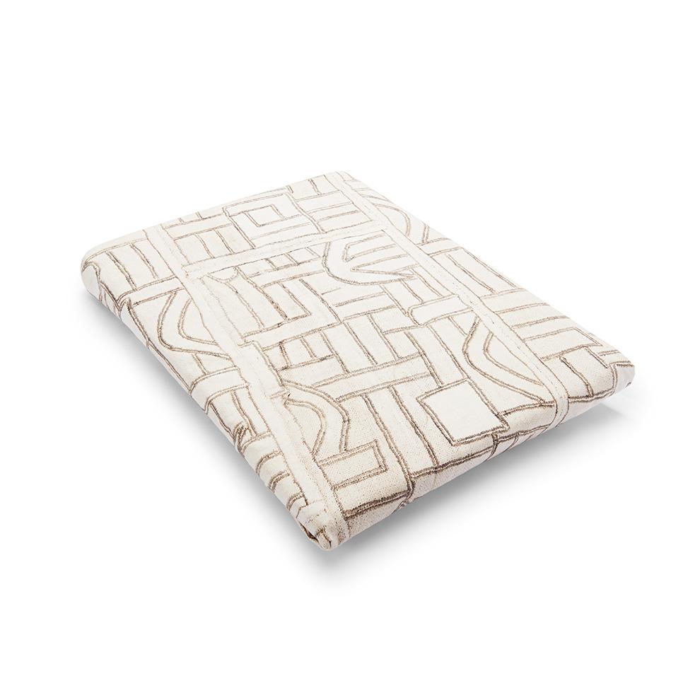 Angled view of Ecru Maze Kuba Cloth Crib Sheet showcasing geometric pattern on white background