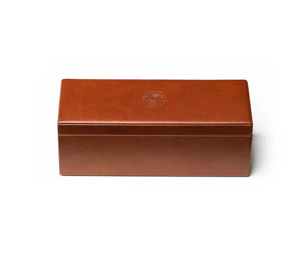 Front view of Domino Set No. 238 closed chestnut leather box showcasing embossed crest on lid on white background