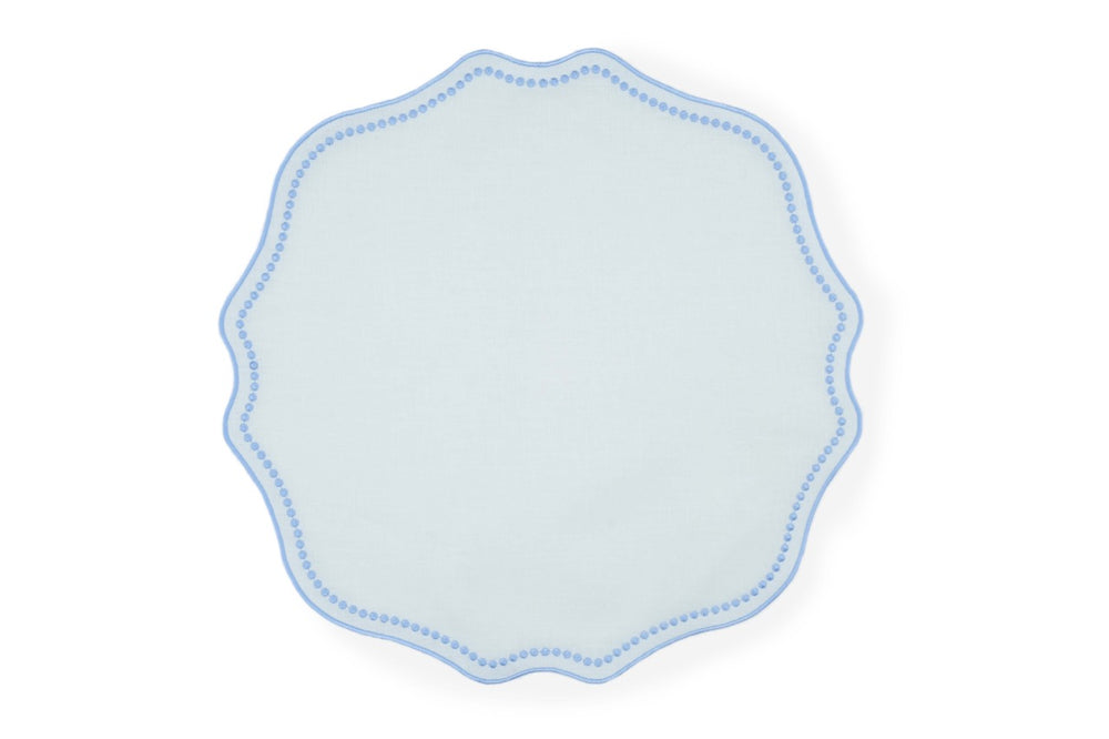 Top view of Blue Dotted White Linen placemat showcasing scalloped edge and blue dotted trim on white background