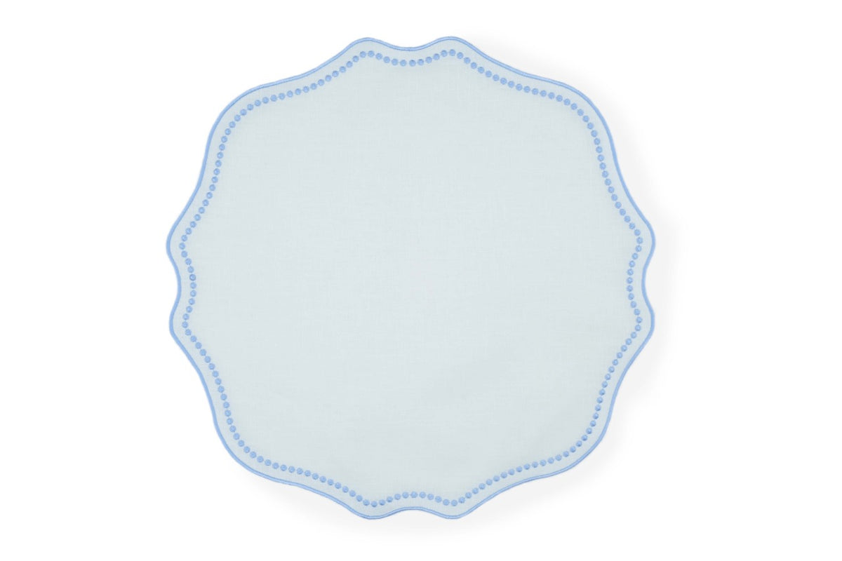 Top view of Blue Dotted White Linen placemat showcasing scalloped edge and blue dotted trim on white background