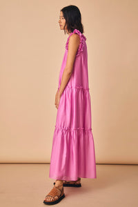 The Davey dress is a sleeveless floor length dress with tiered seams and ruffle accents.