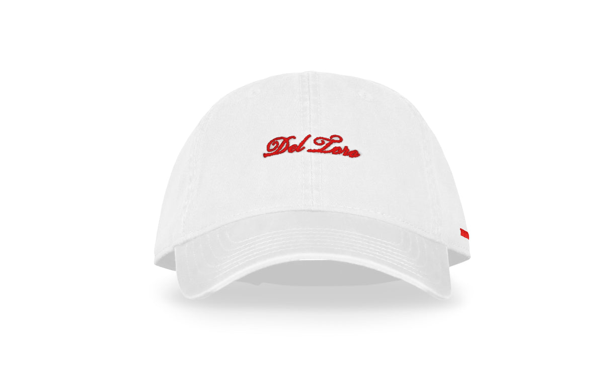 Front view of white embroidered cotton twill adjustable baseball cap showcasing red Del Toro script logo and side stripe against a white background