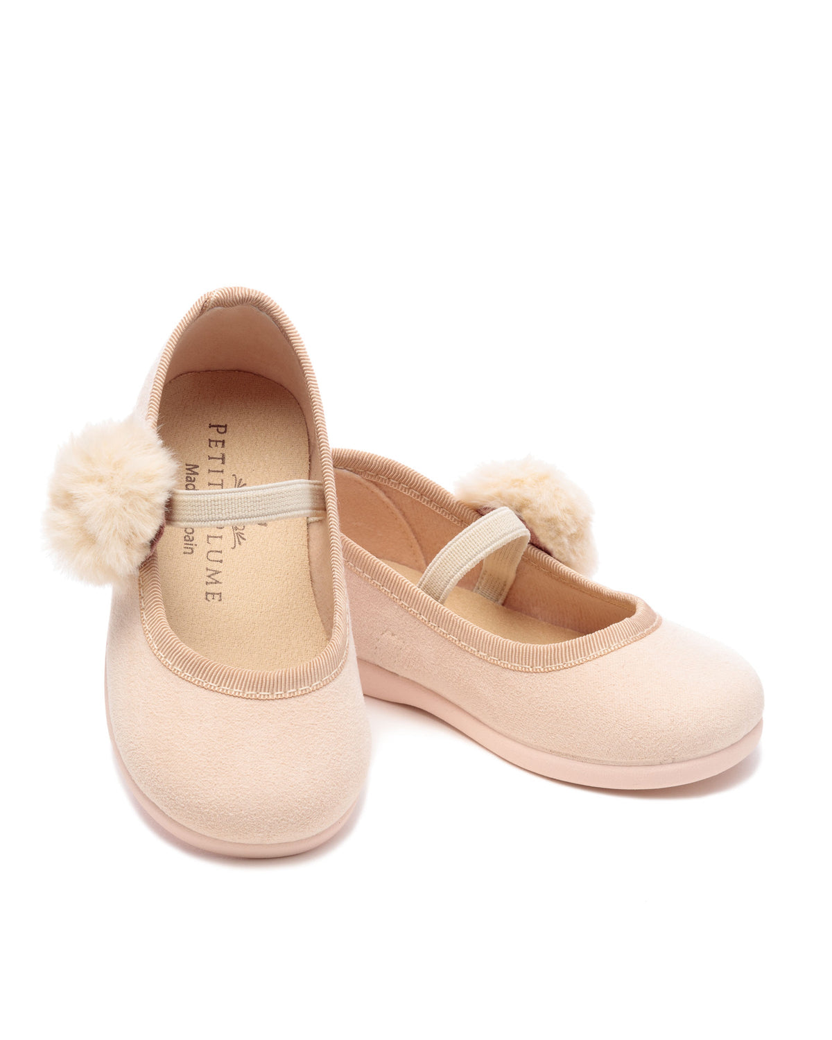 Angled view of The Delphine Slipper in Peach Suede with a Festive Pom showcasing soft insoles against a white background