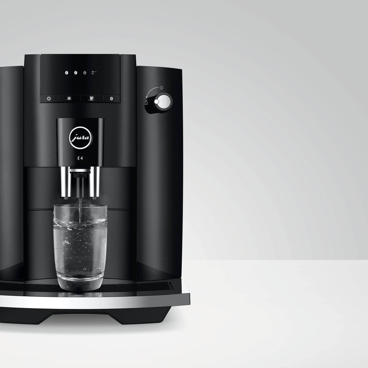 Front view of E4 Fully Automatic Coffee Machine in Piano Black showcasing dual spouts dispensing into a glass with a light background