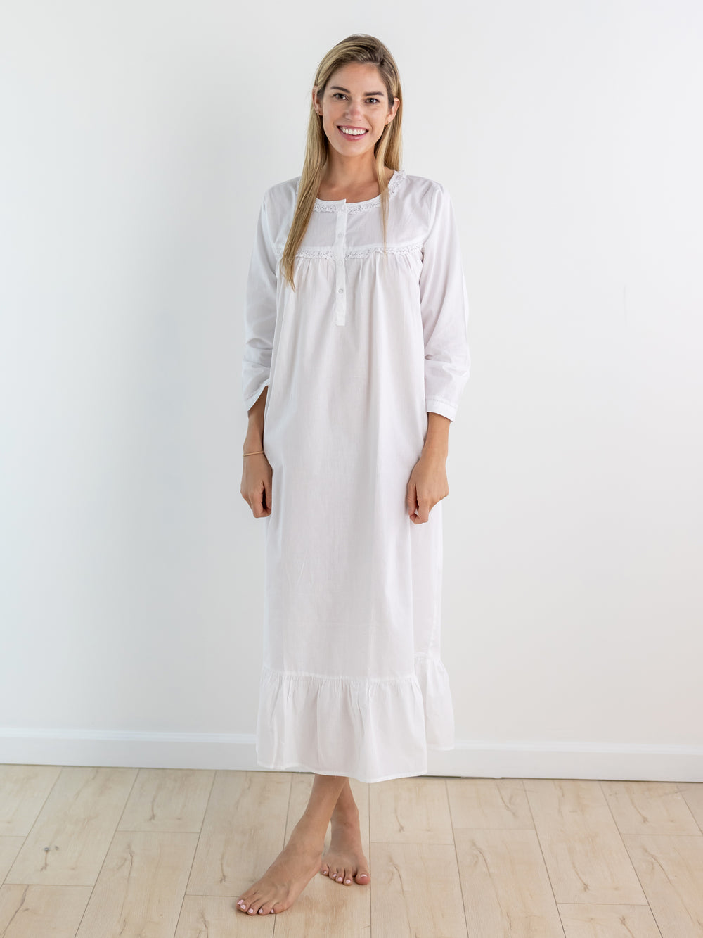 Front view of Catherine white long-sleeve nightgown on model with lace trim and ruffle hem on white background
