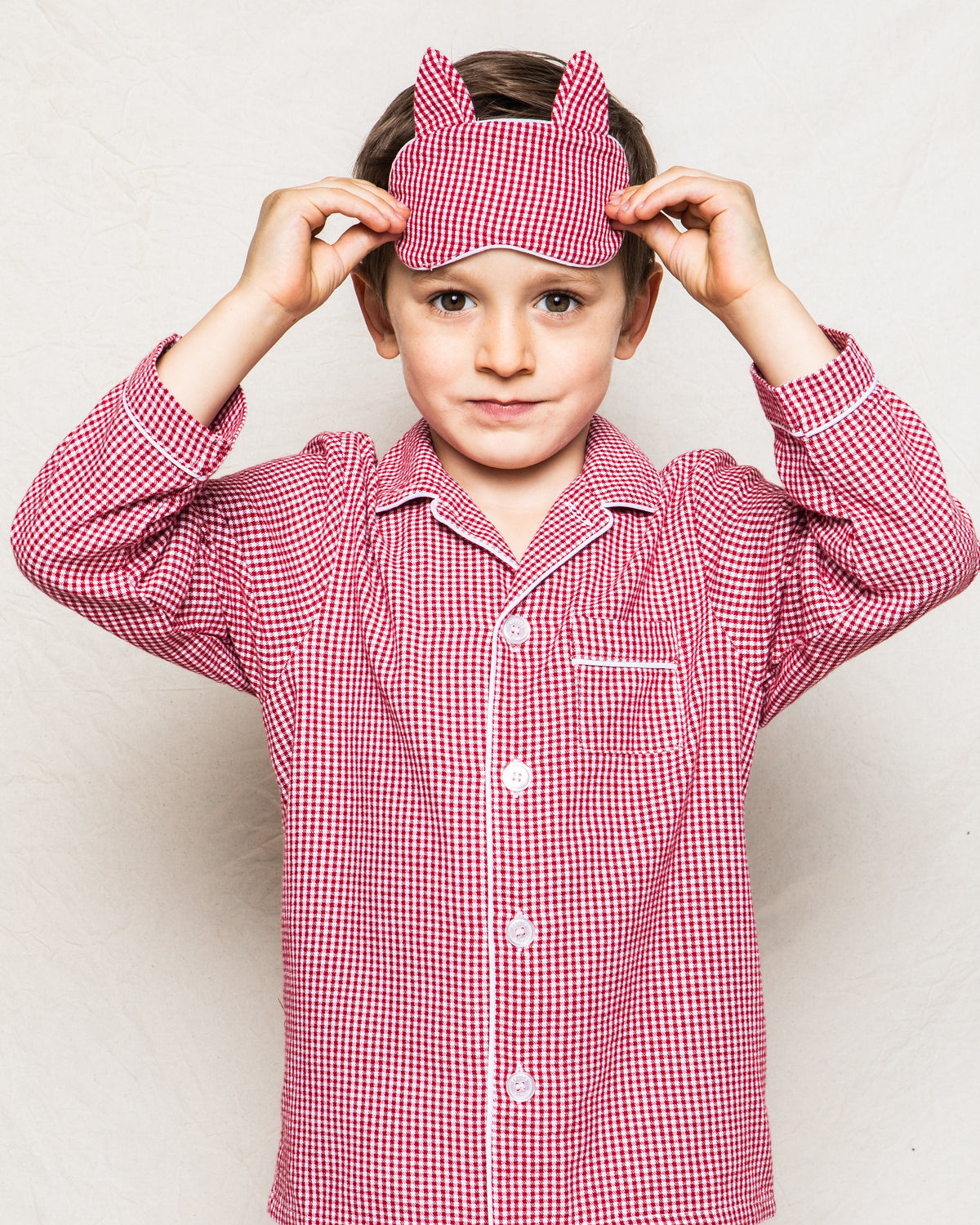 Front view of Children’s Red Mini-Gingham Kitty Sleep Mask showcasing cat ears and red mini-gingham pattern on a child