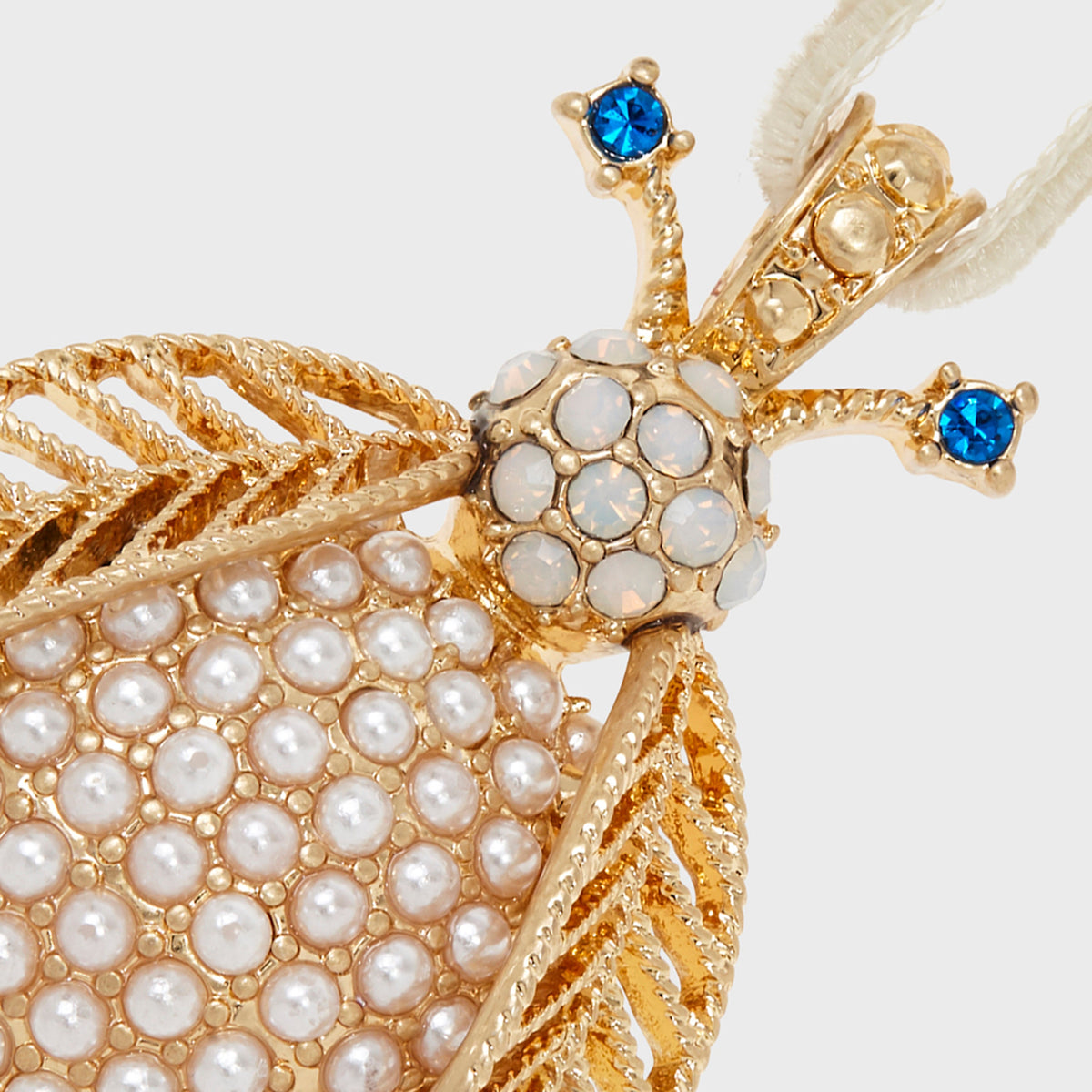 Close-up of Pearl Bug Hanging Ornament showcasing pearl-like beads, blue jeweled accents, and gold-tone details on white