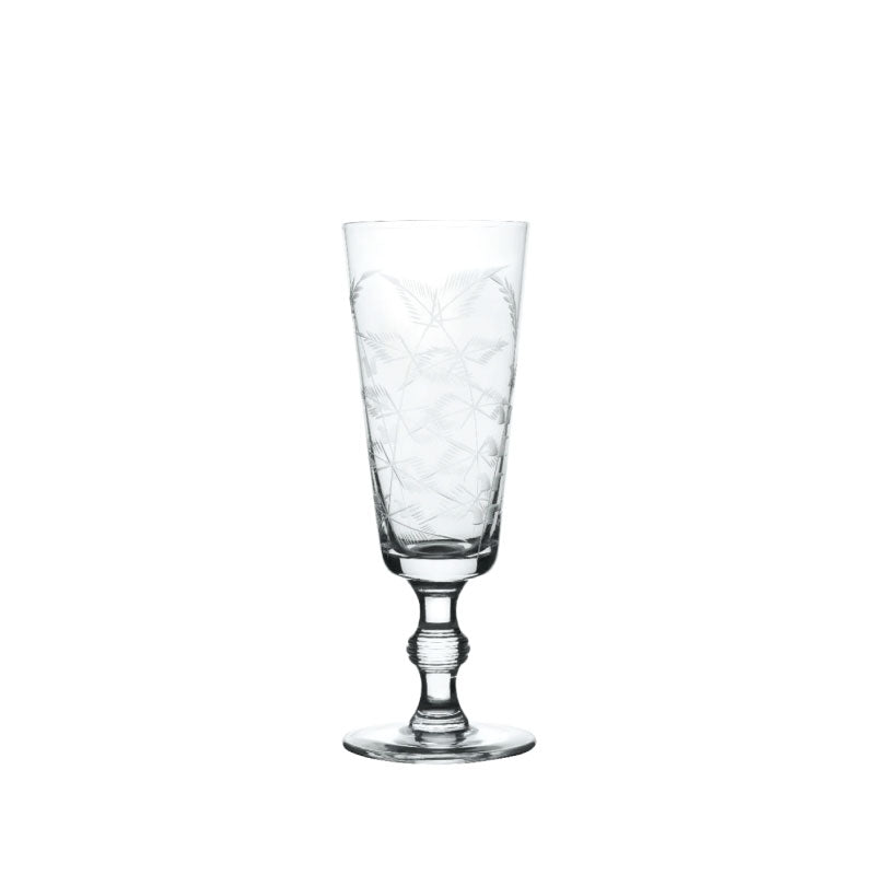 Front view of a crystal champagne flute from the set of four showcasing engraved fern design and short twisted stem on white background