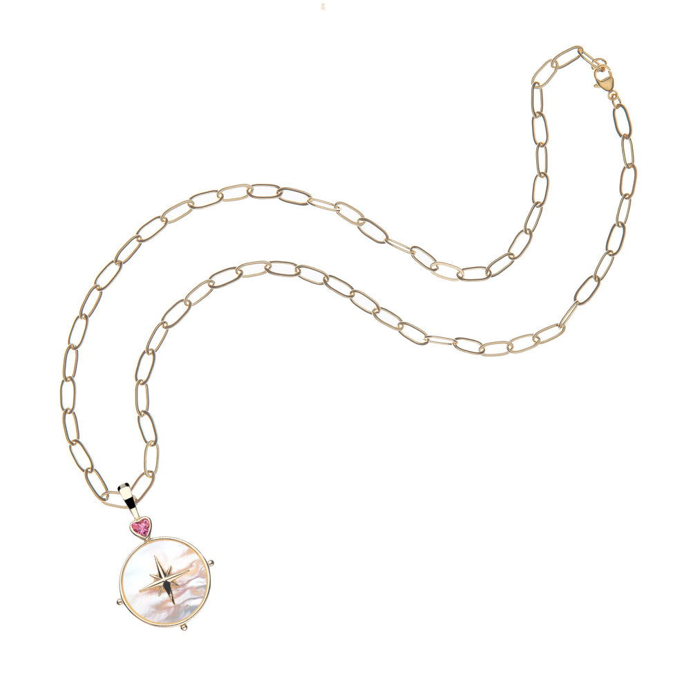 Flat lay of Mother of Pearl North Star pendant necklace with gold star detail and pink tourmaline heart on a gold link chain