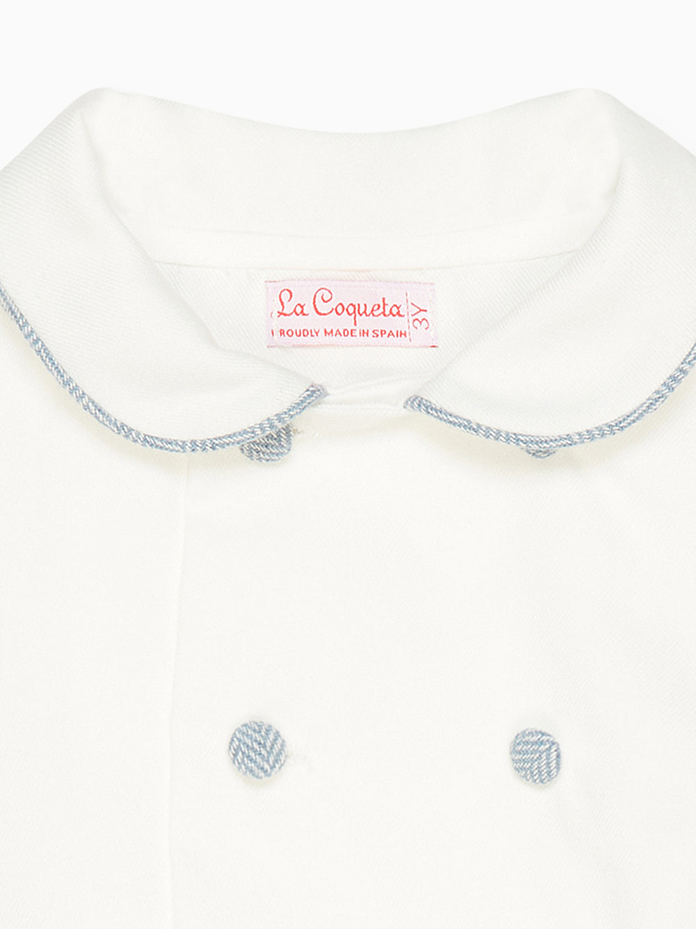 Close-up front of Friso baby boy set top showing Peter Pan collar with blue piped trim and two covered buttons