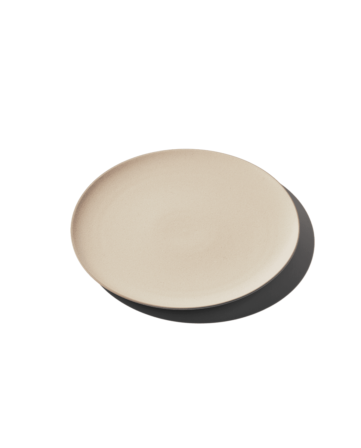 Angled top view of The Full Plate in dune beige showing shallow rim and matte ceramic finish on plain background with shadow