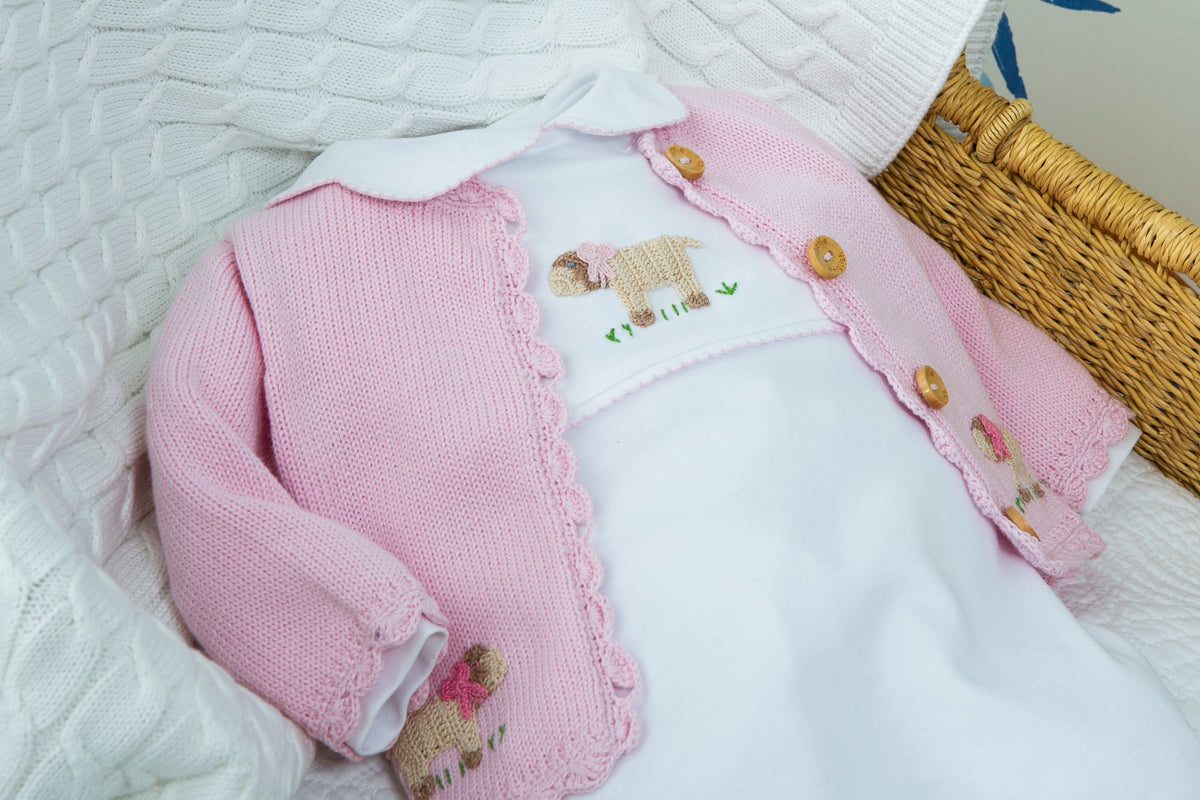 Close-up of Girl Sheep crochet playsuit showing white playsuit with embroidered sheep and pink scalloped knit cardigan