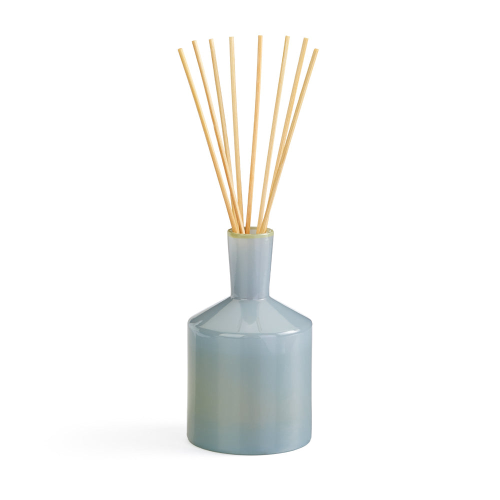 Front view of Sea & Dune Reed Diffuser showcasing pale blue glass vessel and natural rattan reeds against a white background