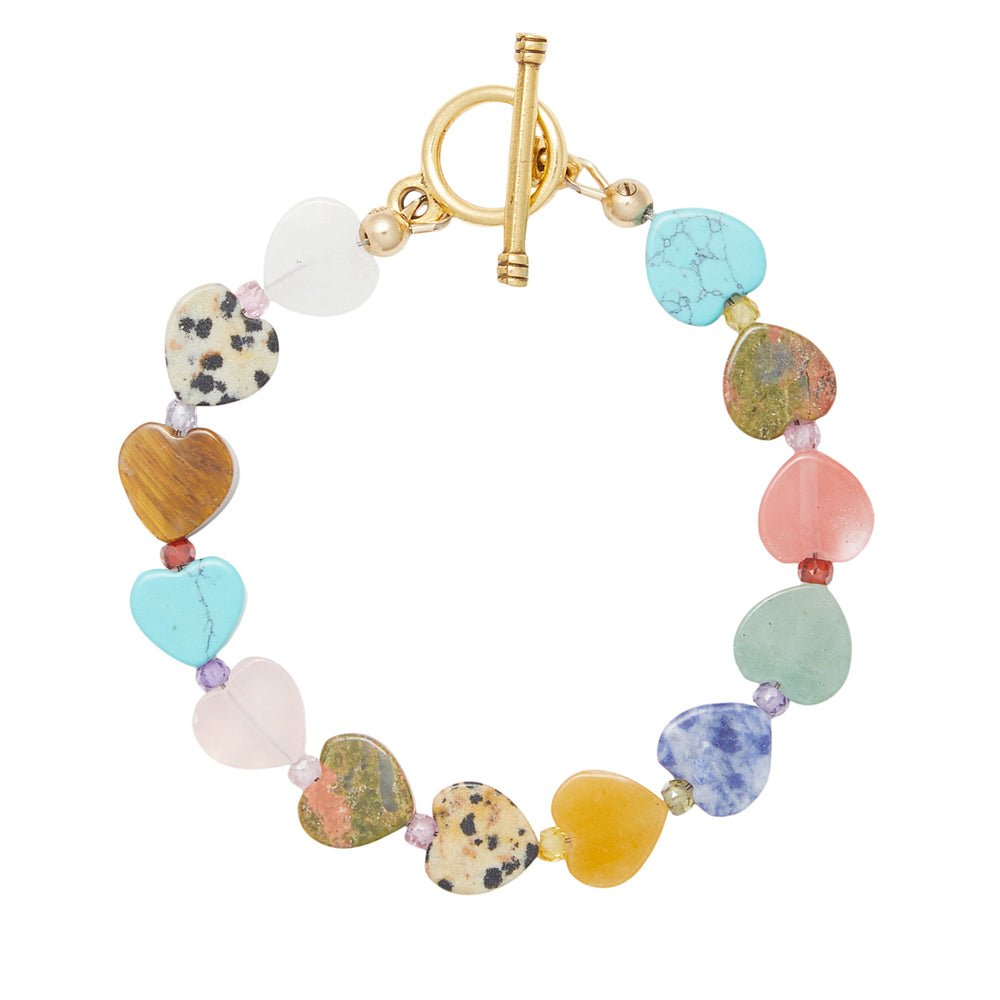 Top-down view of Heidi Bracelet with heart-shaped multicolored semi-precious beads and gold toggle clasp on white background