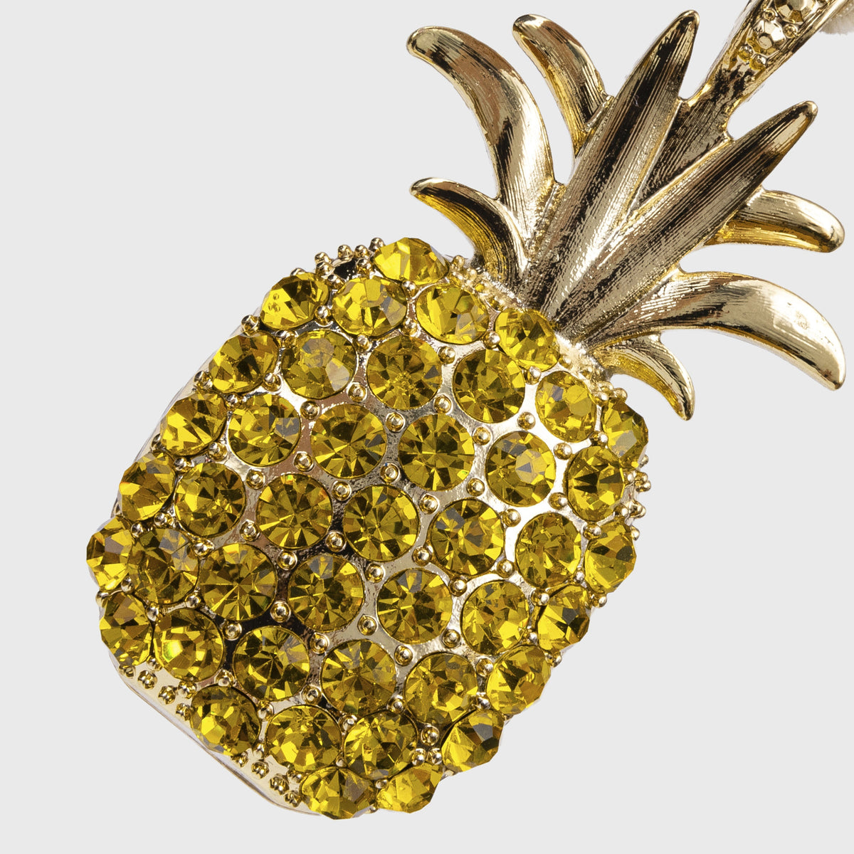 Close-up of Pineapple Hanging Ornament in Yellow with faceted yellow embellishments and metallic leaves on gray