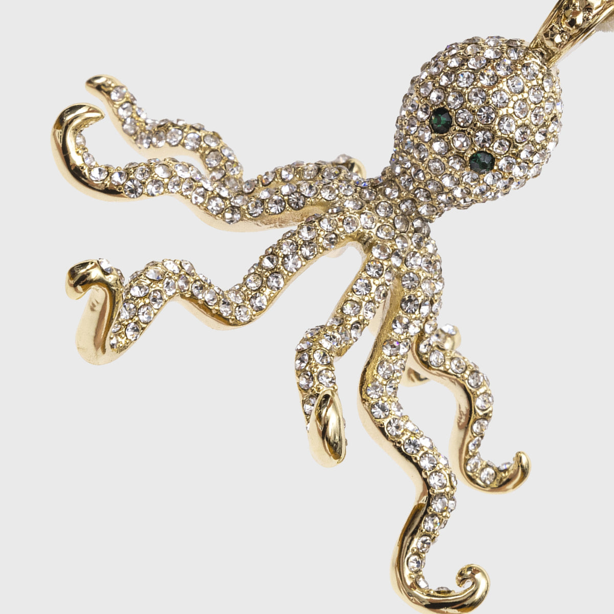 Close up of Octopus Hanging Ornament showcasing crystal covered zinc body and green gem eyes against a white background