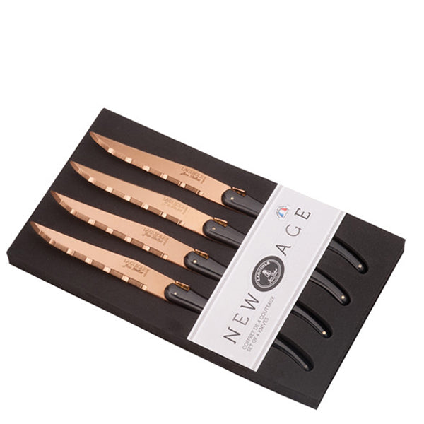 Angled view of Steak Knives in New Age Copper, Set of 4 showcasing serrated 4.5-inch blades and black handles in a gift box