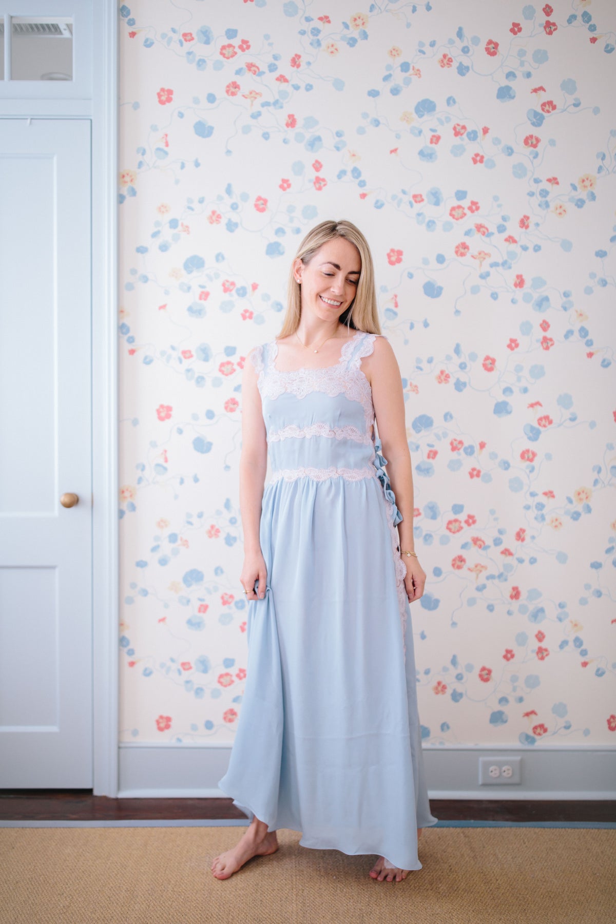 Full-length view of Sabina Silk Nightgown, light blue on model, showing lace-trimmed bodice, spaghetti straps and side ribbon ties