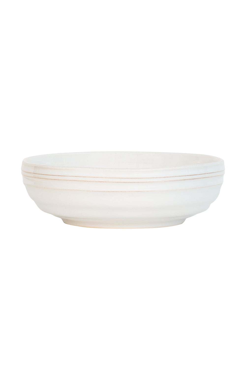 Side view of Bilbao Whitewash coupe bowl showing hand‑hewn horizontal ridges and matte whitewash ceramic on a white background