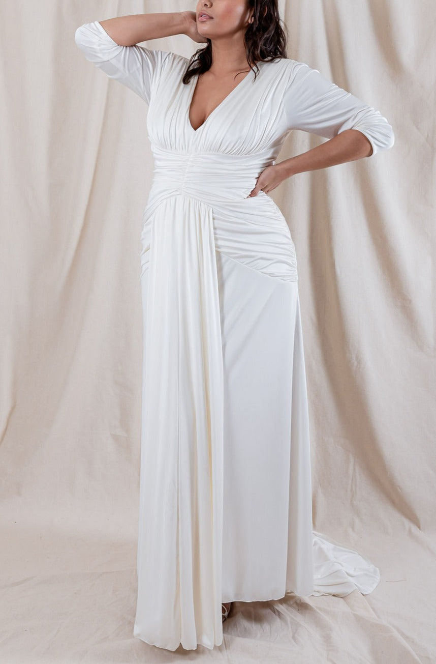 Three-quarter view of Nicole Silk Ruched Gown showing V-neck, ruched waist, draped front panel in ivory silk jersey on beige backdrop