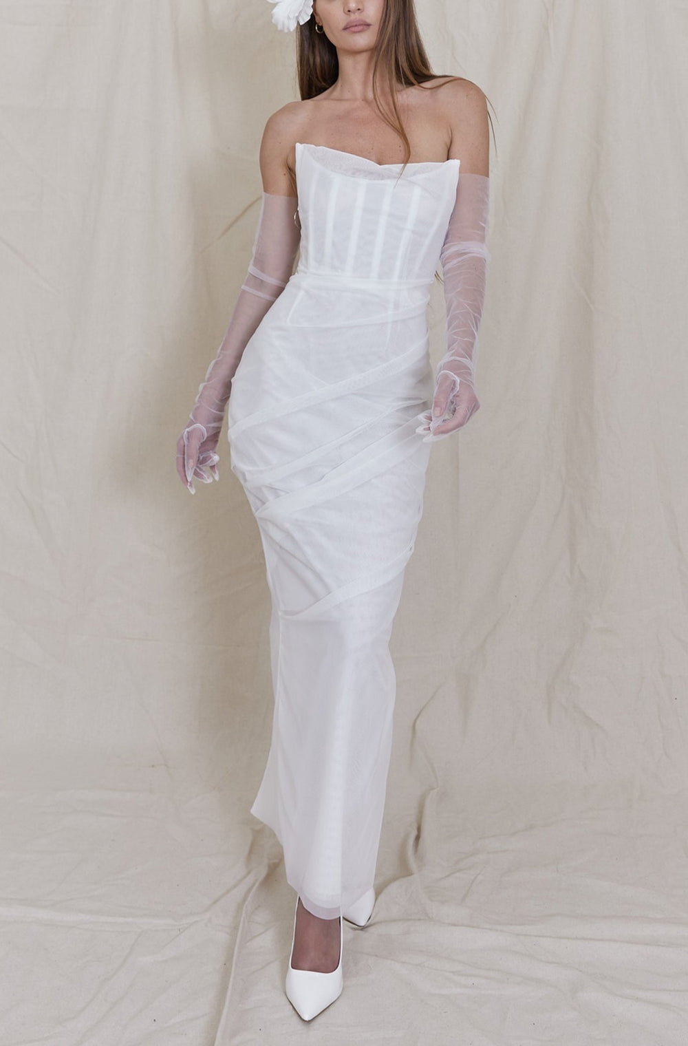 Front view of Khloe Cocktail Dress, white strapless corset and fitted column skirt with ruched tulle on beige backdrop