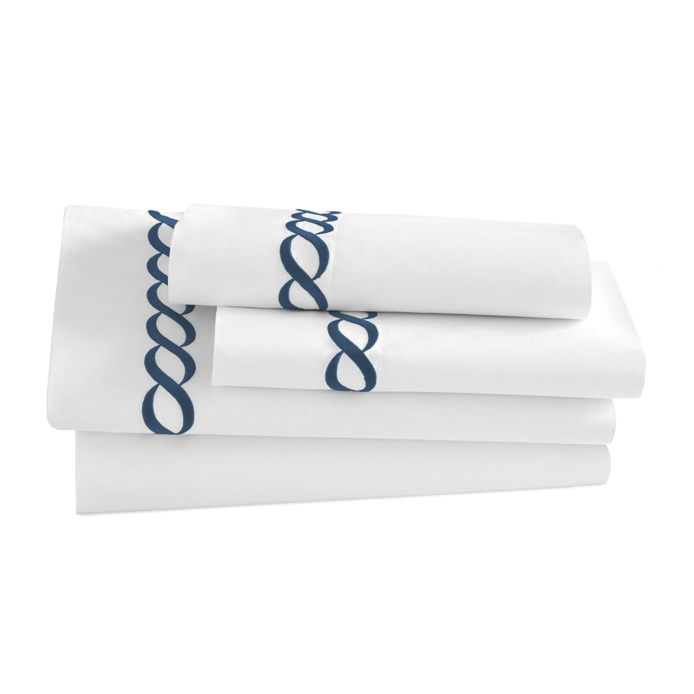 Stacked view of Catena Full/Queen flat sheet set showcasing navy embroidered cable border on white background