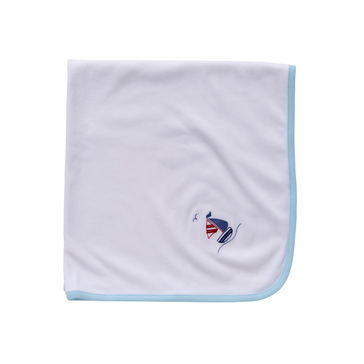 Flat lay of baby blanket showcasing light blue binding and small embroidered sailboat on white background