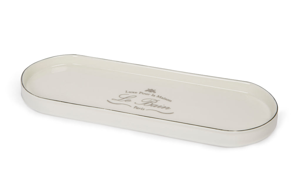 Angled top view of Le Bain porcelain tray showcasing platinum-toned rim and printed Le Bain script on white