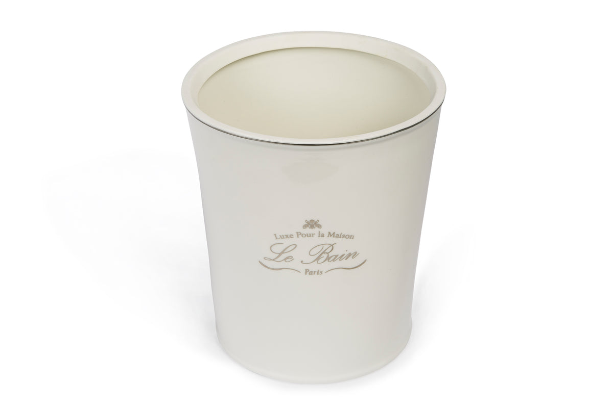 Three-quarter top view of Le Bain waste basket showing white porcelain body and silver-toned rim on a white background