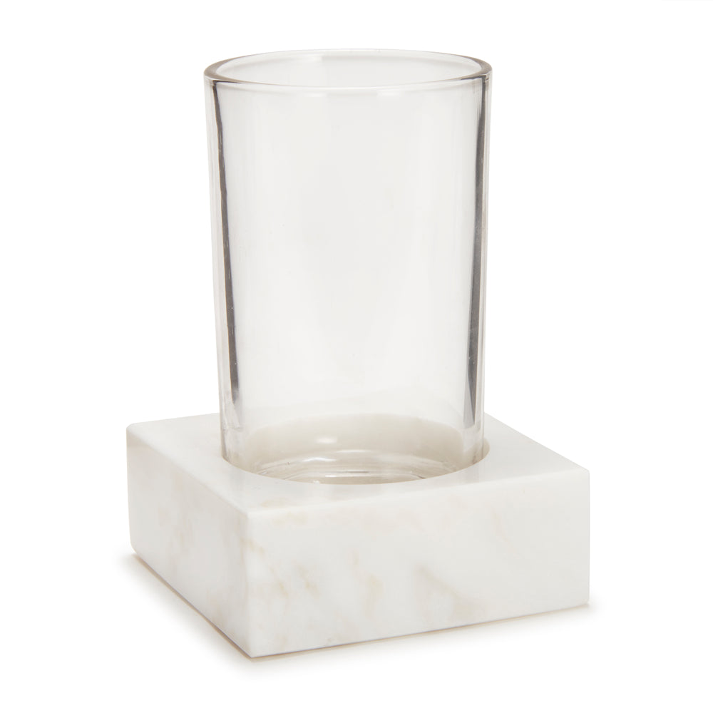 Angled front view of Marmol Bath Tumbler showing a clear glass cup set in a square white marble base on white background