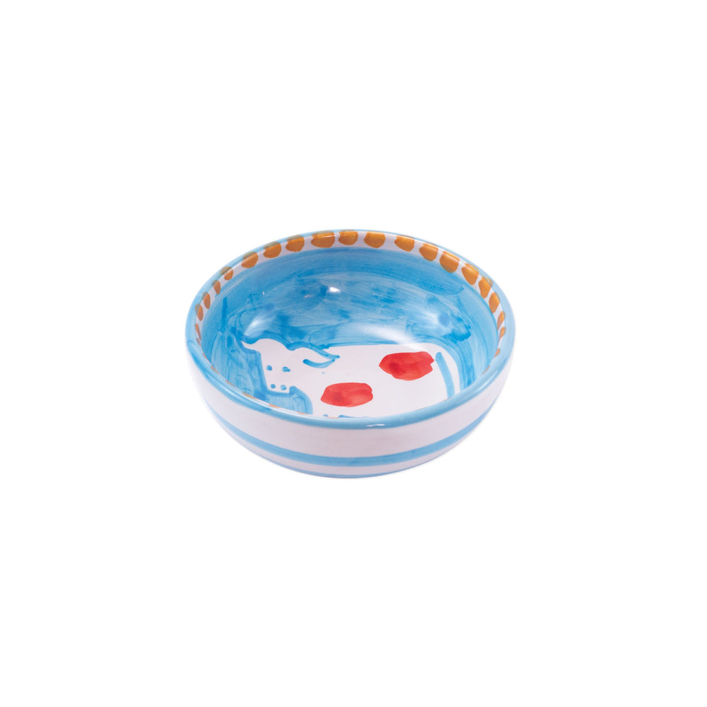 Three-quarter view of Campagna Olive Oil Bowl showing hand-painted blue interior with cow motif, red spots, and orange rim dots on white background