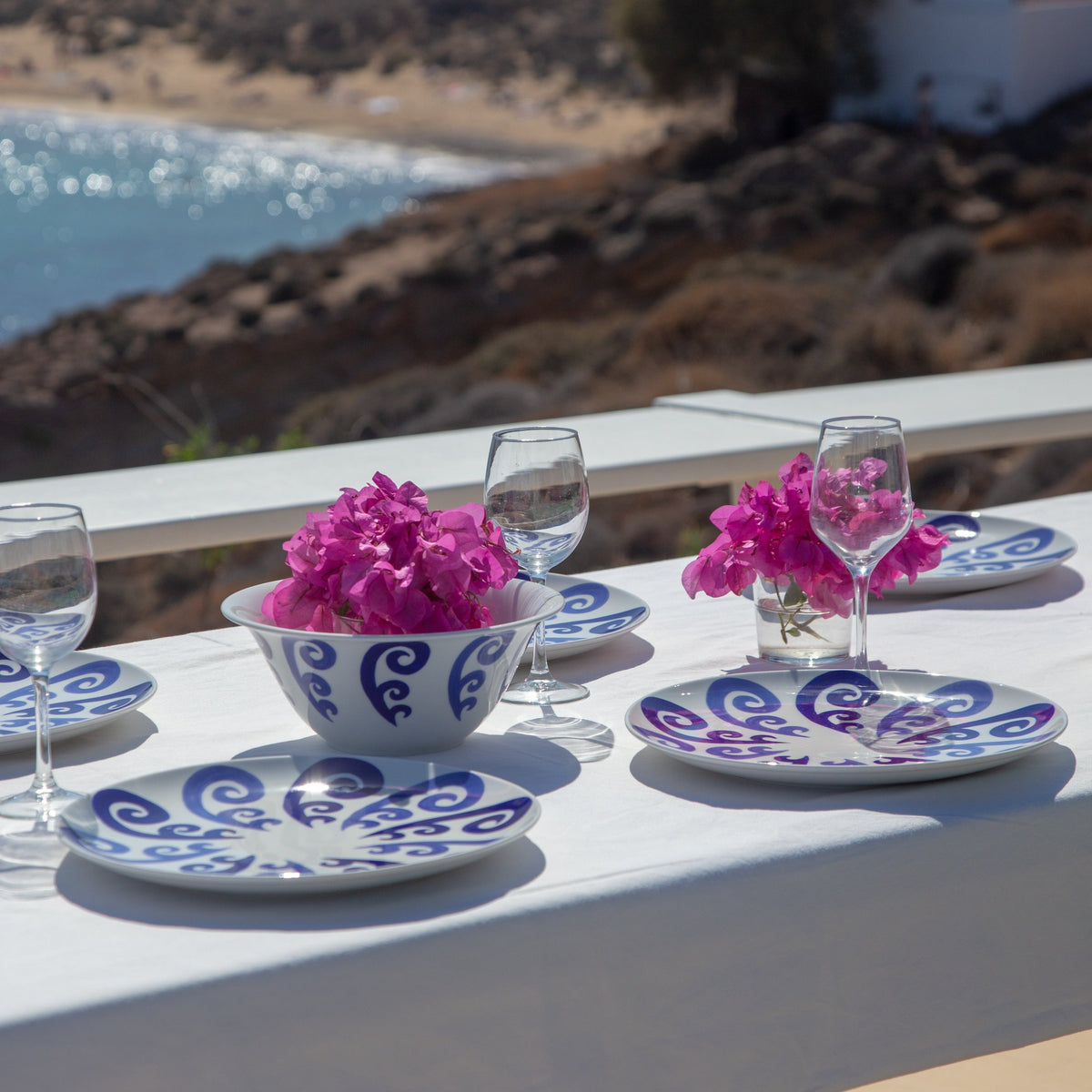Angled view of Athenee Two Tone Blue Peacock dinner plate showing blue peacock swirl on white porcelain on outdoor table
