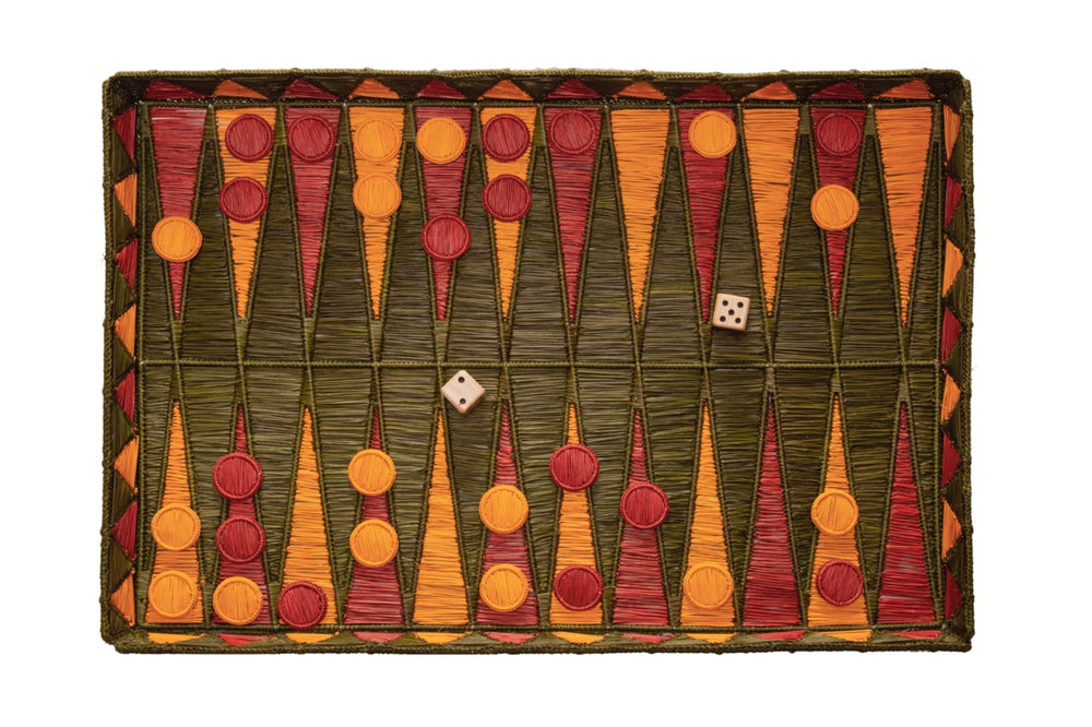 Top-down view of olive green backgammon set showing iraca palm board with orange and red points, pieces and two dice on white