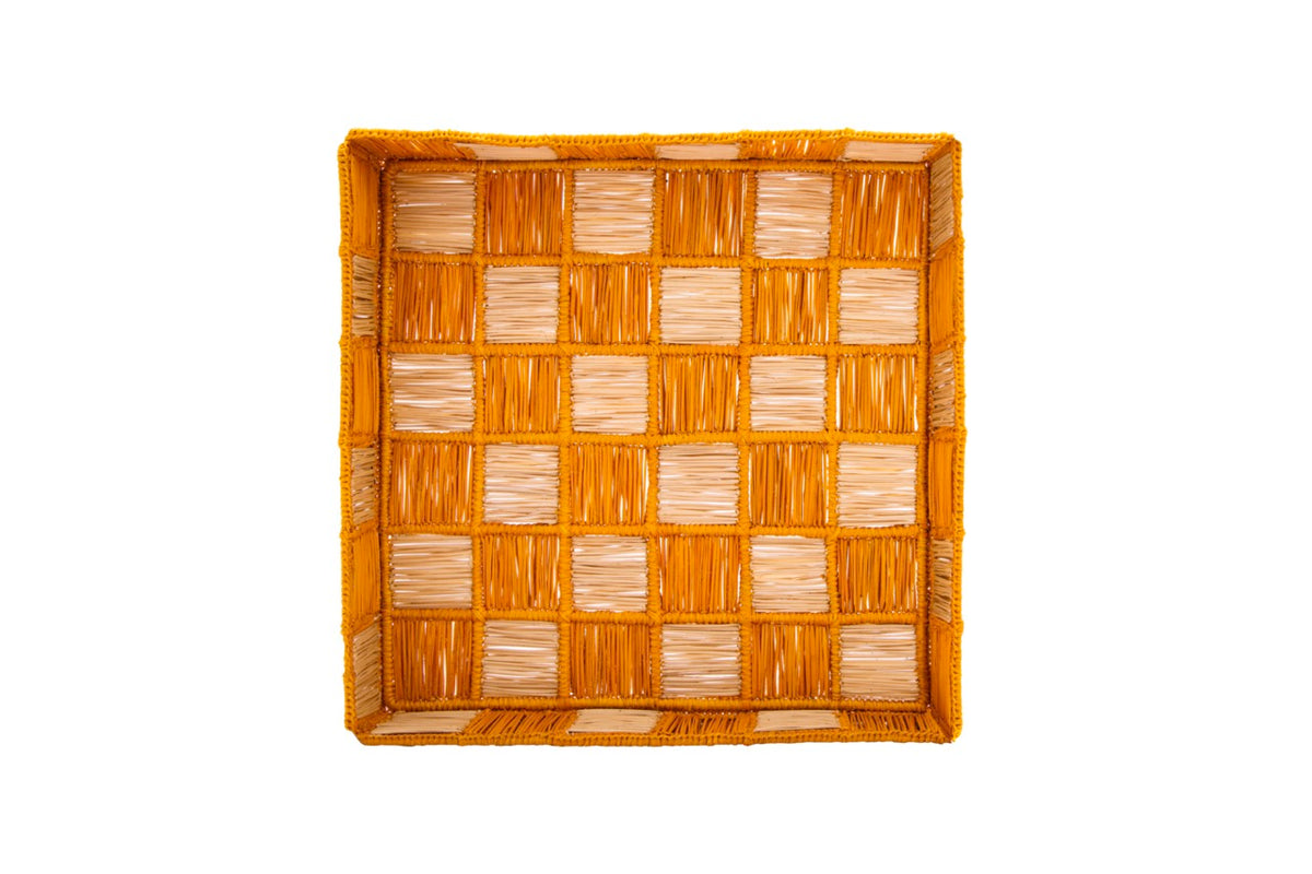 Top-down view of Damero large square tray showcasing woven iraca palm checkerboard pattern and orange trim on white background