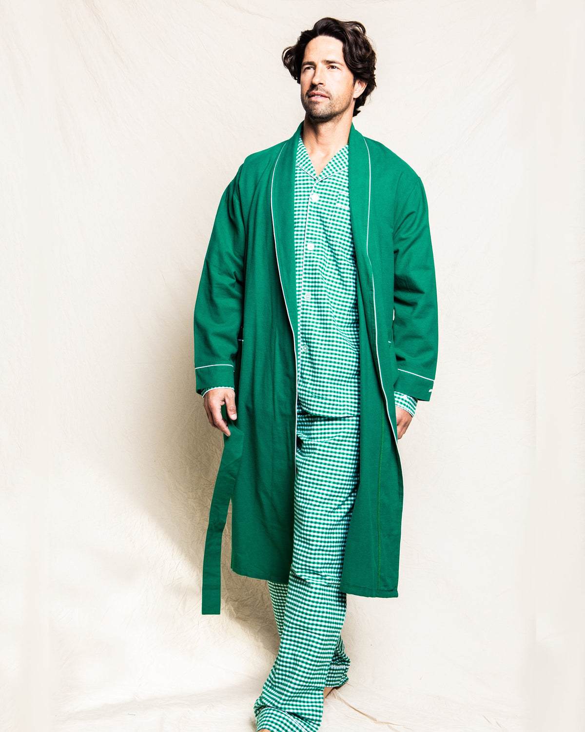 Front view of men’s forest green flannel robe showcasing white piping and open front on a model against a cream background