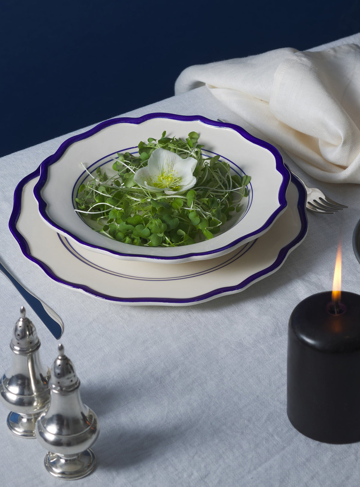 Angled top view of Jane Pasta Bowl, set of 4 showcasing scalloped edges and hand-painted purple rim on a white tablecloth