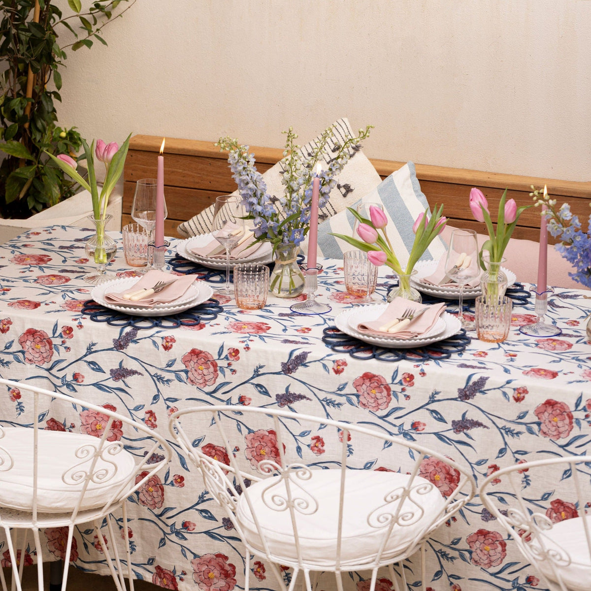 Angled view of Juliet tablecloth showcasing pink and blue floral print on cream linen on a set dining table
