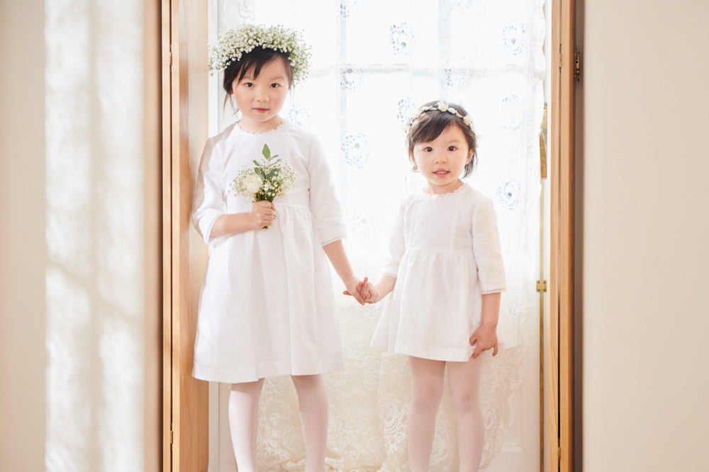 Front view of Margarita Ceremony baby dress in ivory on two child models, Mandarin collar, three-quarter sleeves, lace trim