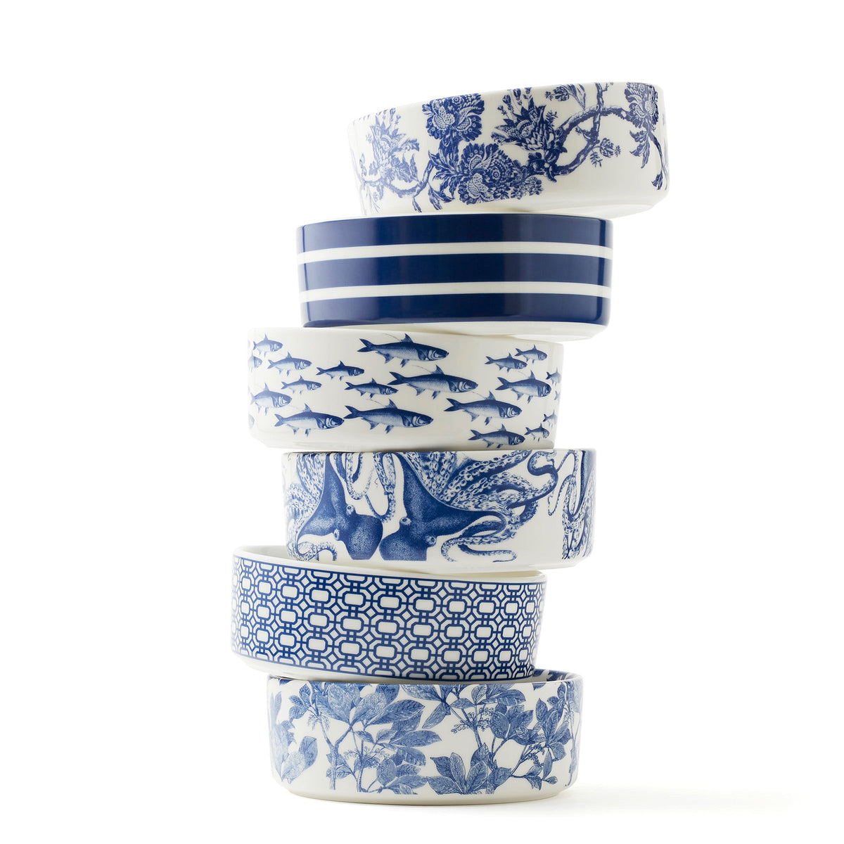 A stack of Arbor, Newport Garden Gate, Arcadia, Beach Towel Stripe, School of Fish and Lucy the Octopus Medium Pet Bowls. Premium porcelain from Caskata.