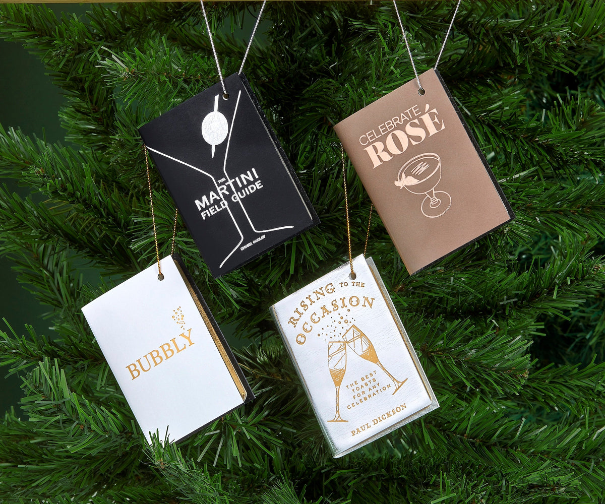 Front view of Mini Leather Ornaments: Holiday Cheer showcasing four book-shaped leather ornaments on a Christmas tree