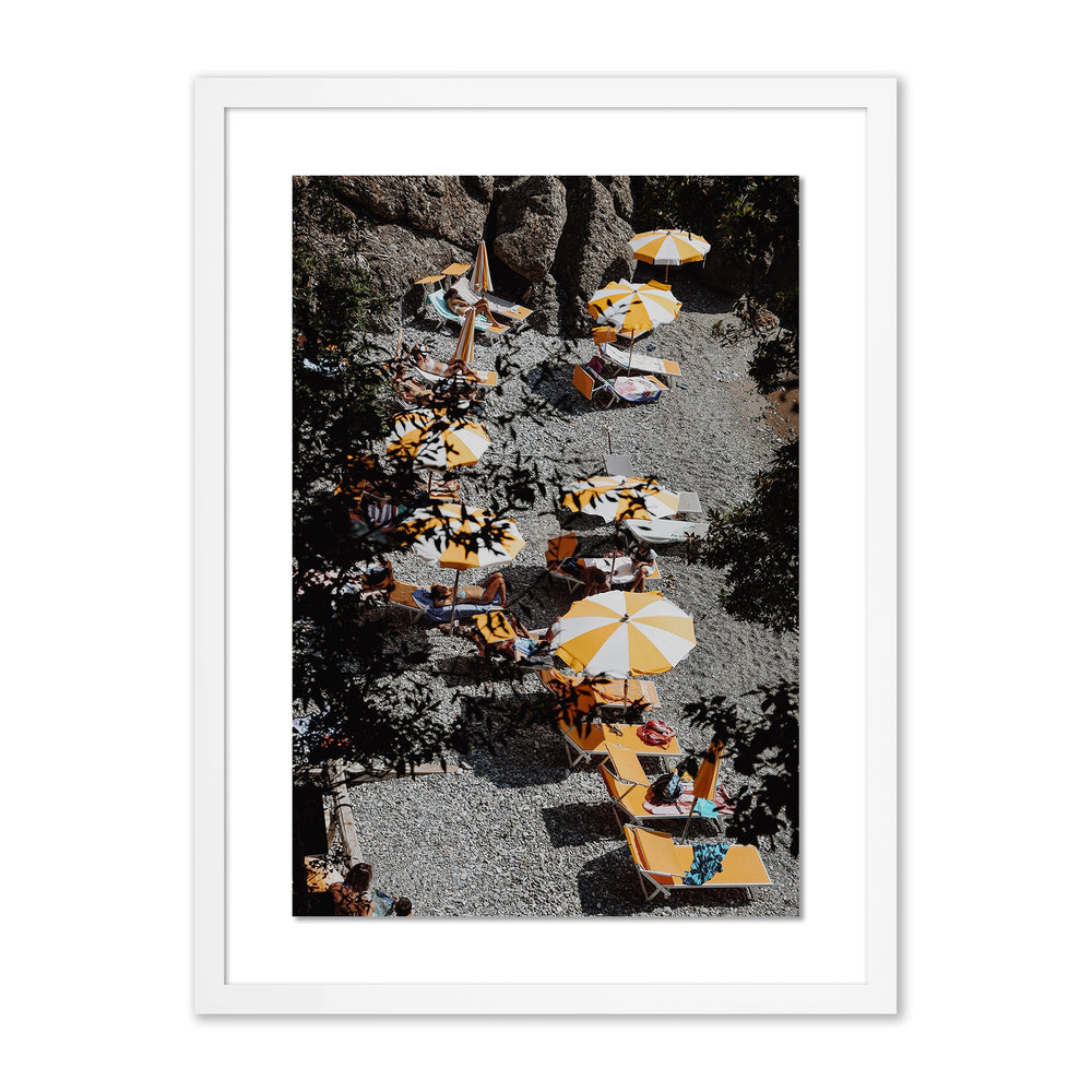 Framed La Cantina print showing aerial view of yellow and white umbrellas and lounge chairs on a pebble beach
