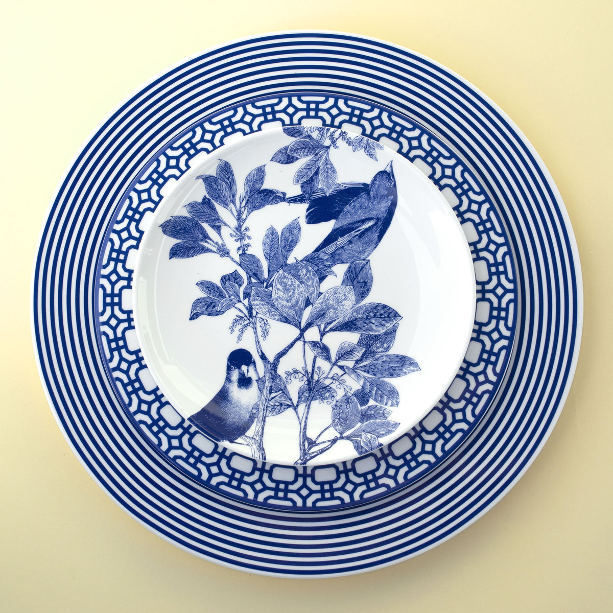 Top view of Newport Place Setting, Set of 4 showcasing blue geometric and botanical patterns on creamy white porcelain