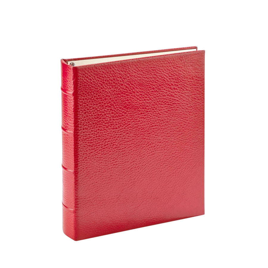 Angled view of Medium Ring Clear Pocket Album with pebbled red leather, raised spine bands, and metal rings on white