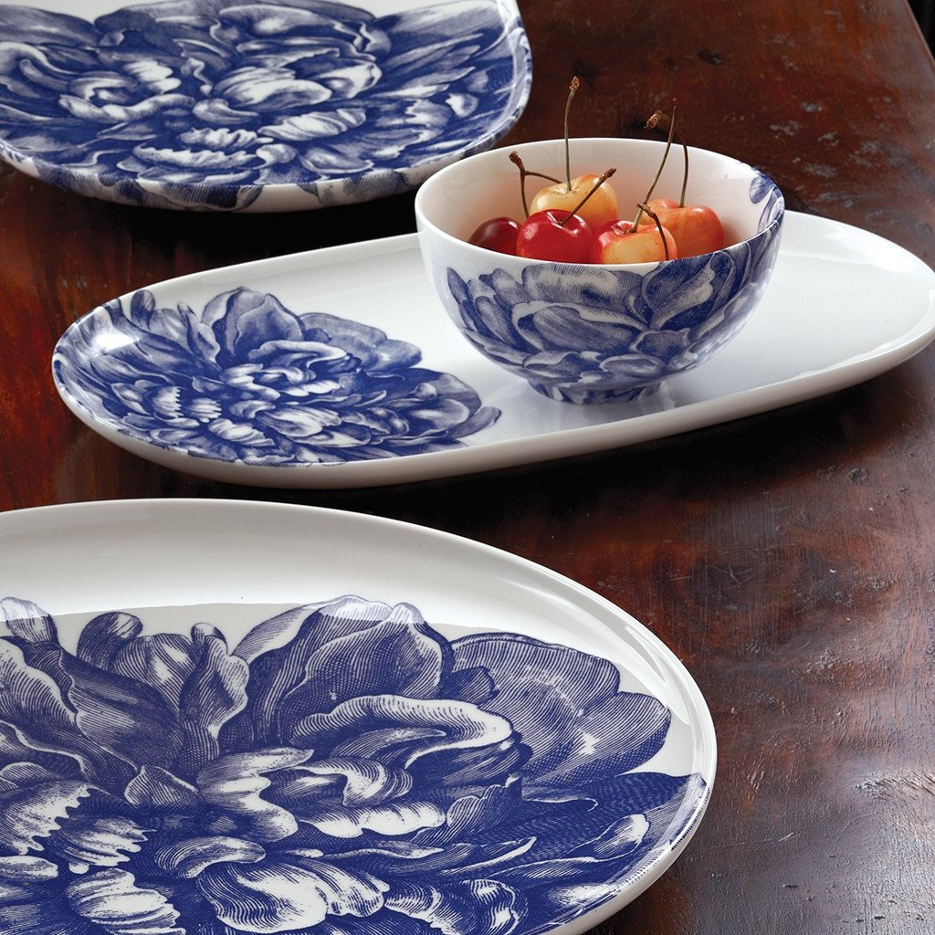 Peony Blue Snack Bowl holding cherries among matching floral dinnerware on a wooden table